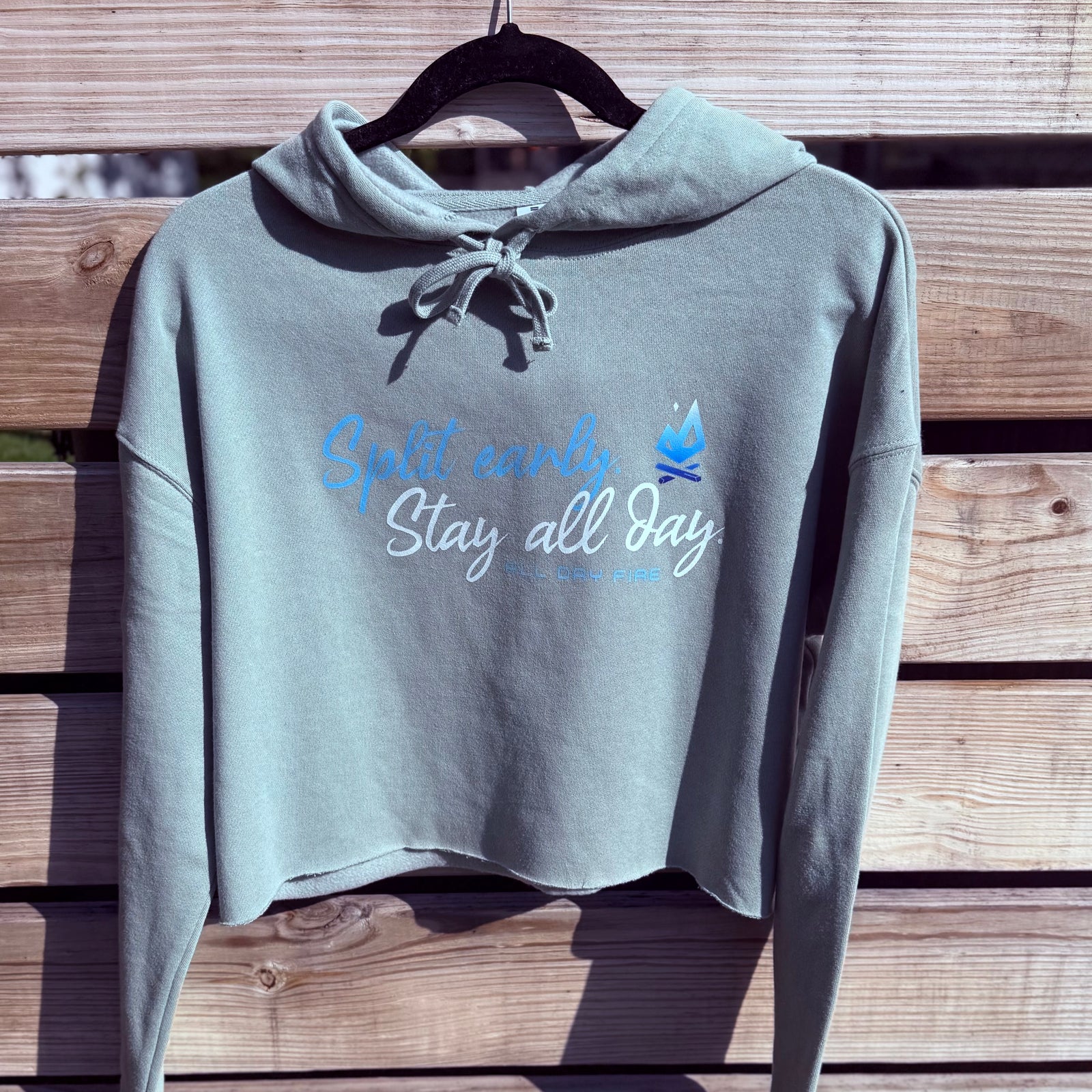 Sage cropped hoodie featuring Split Early Stay All Day design and All Day Fire logo. Lightweight outdoor hoodie for camping and everyday comfort.