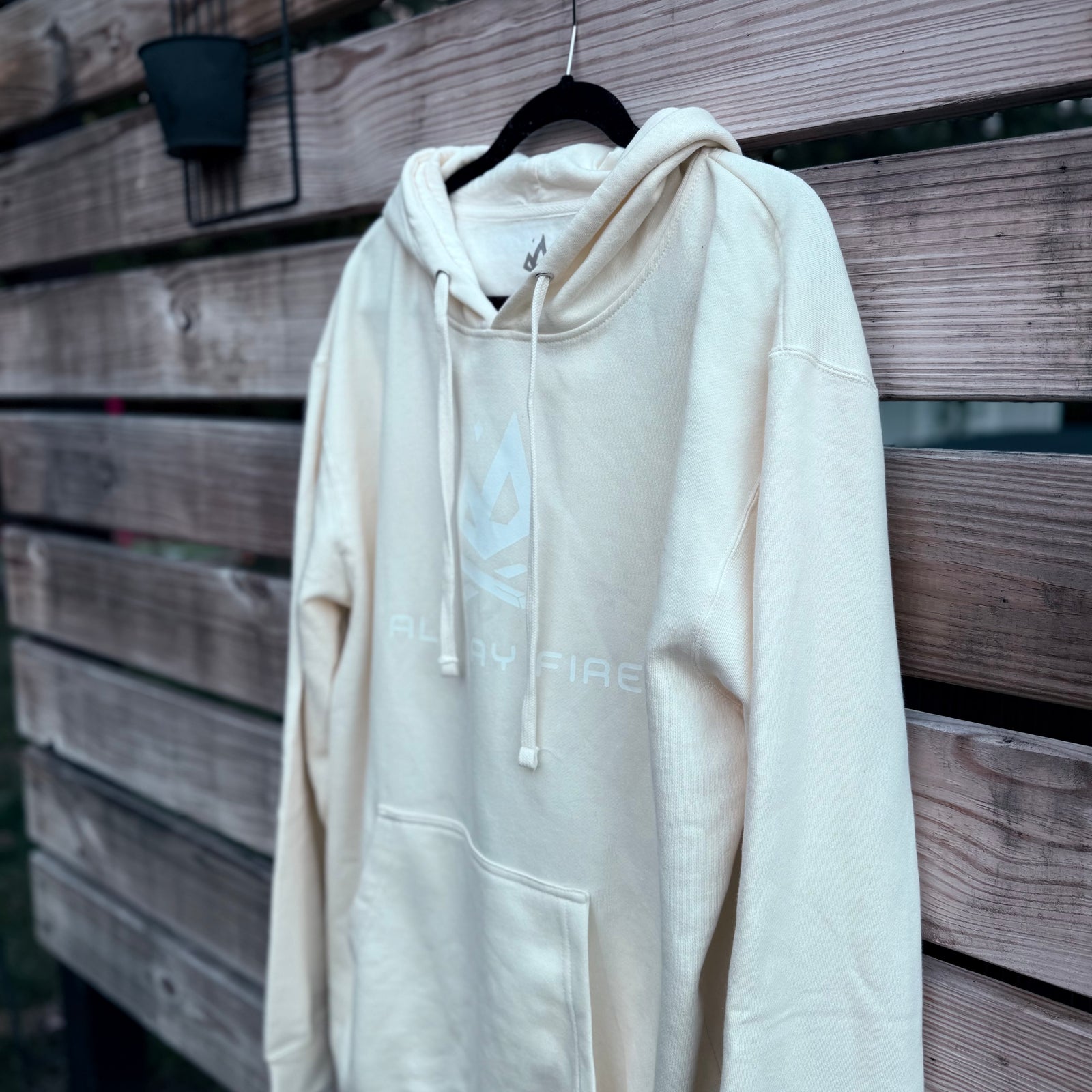 Bone-colored hoodie featuring the white All Day Fire Outfitters logo on the front. Outdoor-inspired fleece hoodie made for comfort and adventure.