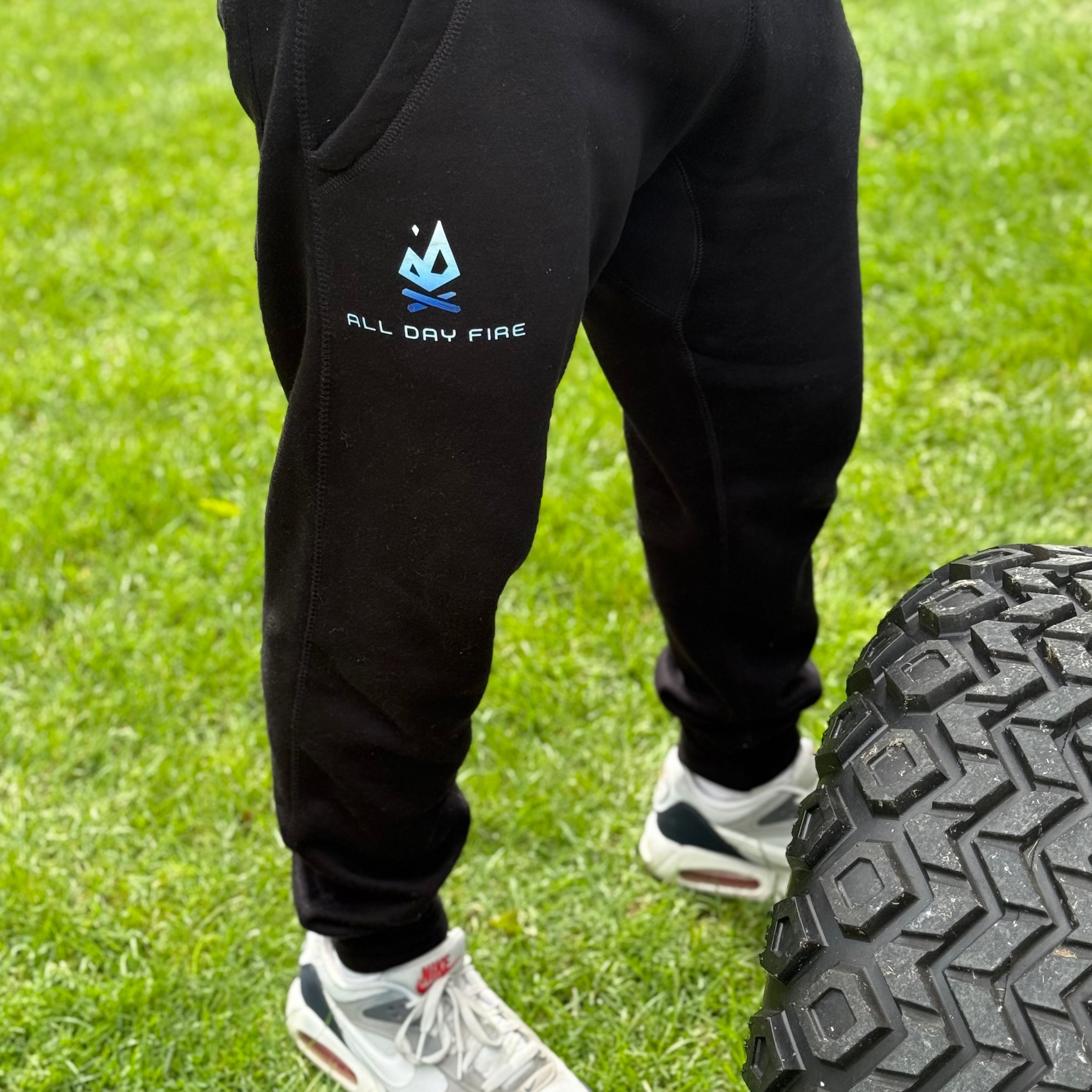 Men’s black joggers featuring the All Day Fire Outfitters logo. Comfortable outdoor joggers made for camping, bonfires, and relaxed adventures.