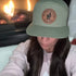 Woman wearing Copper Top Edition leather patch hat outdoors. Pale khaki and loden green Richardson 168 hat perfect for campfires and everyday wear.