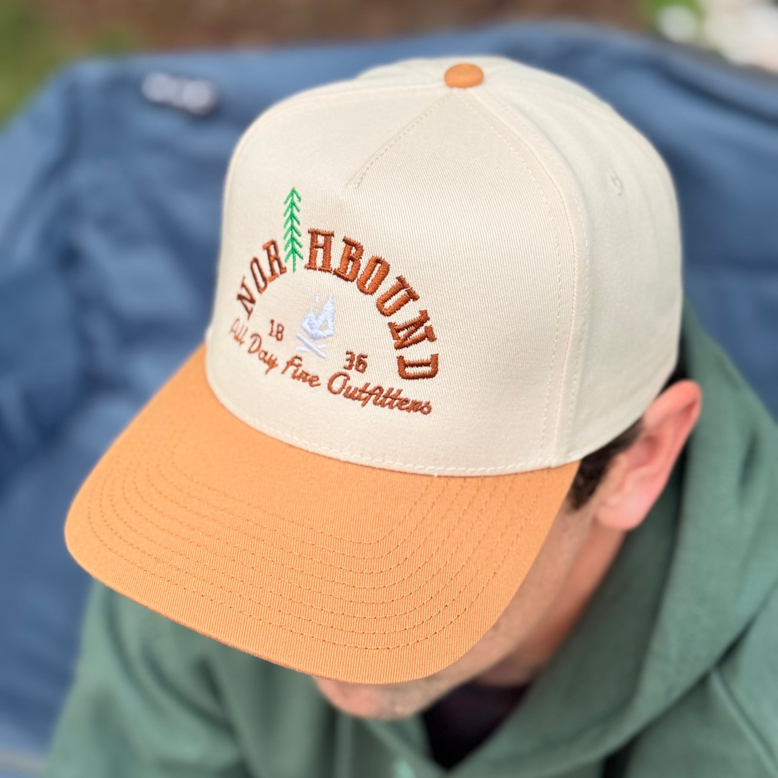 Northbound Richardson 323 snapback hat at a campsite, inspired by Michigan camping and Up North living.