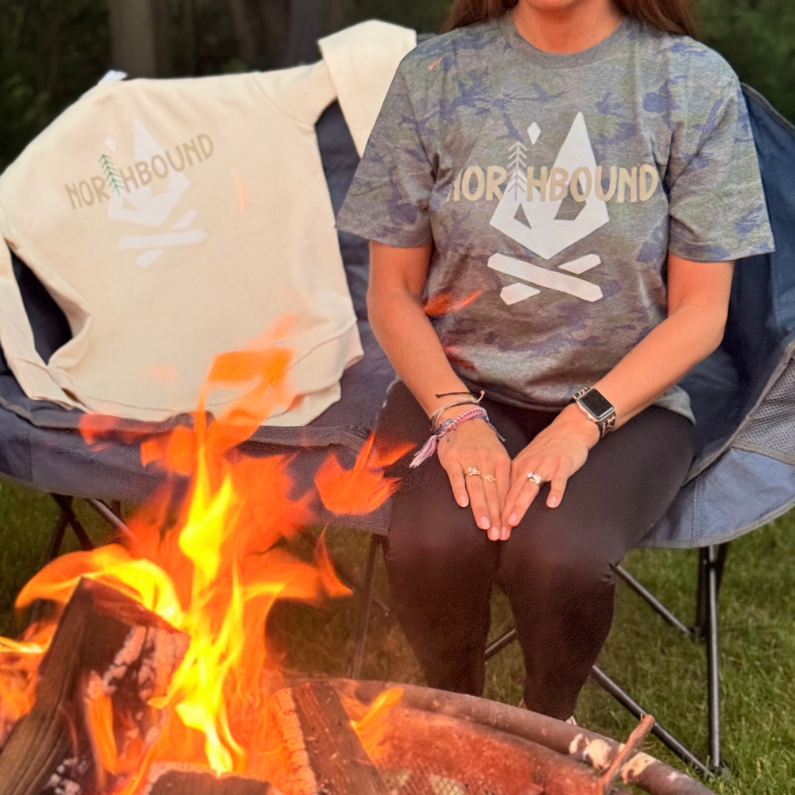 Person wearing Northbound Vintage Camo Tee outdoors while camping and enjoying time around the fire.