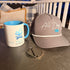 Stay Awhile Bundle with Richardson 168 All Day Fire hat and ceramic mug on outdoor table near fire pit.
